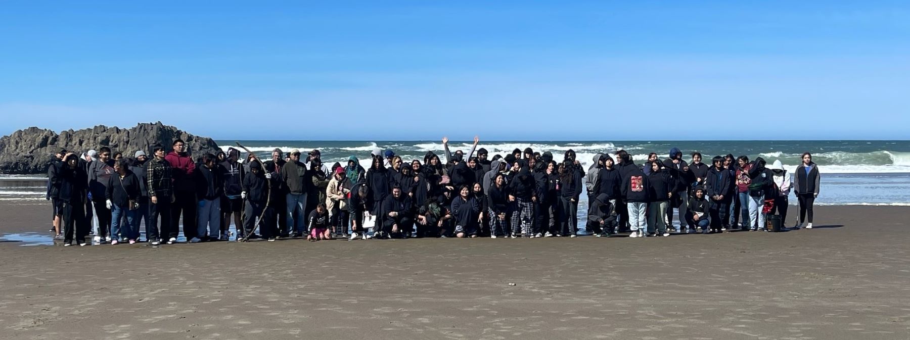 A very large group of people standing on the beach.