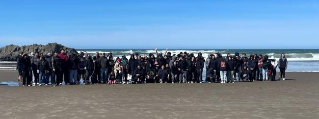 A very large group of people standing on the beach.